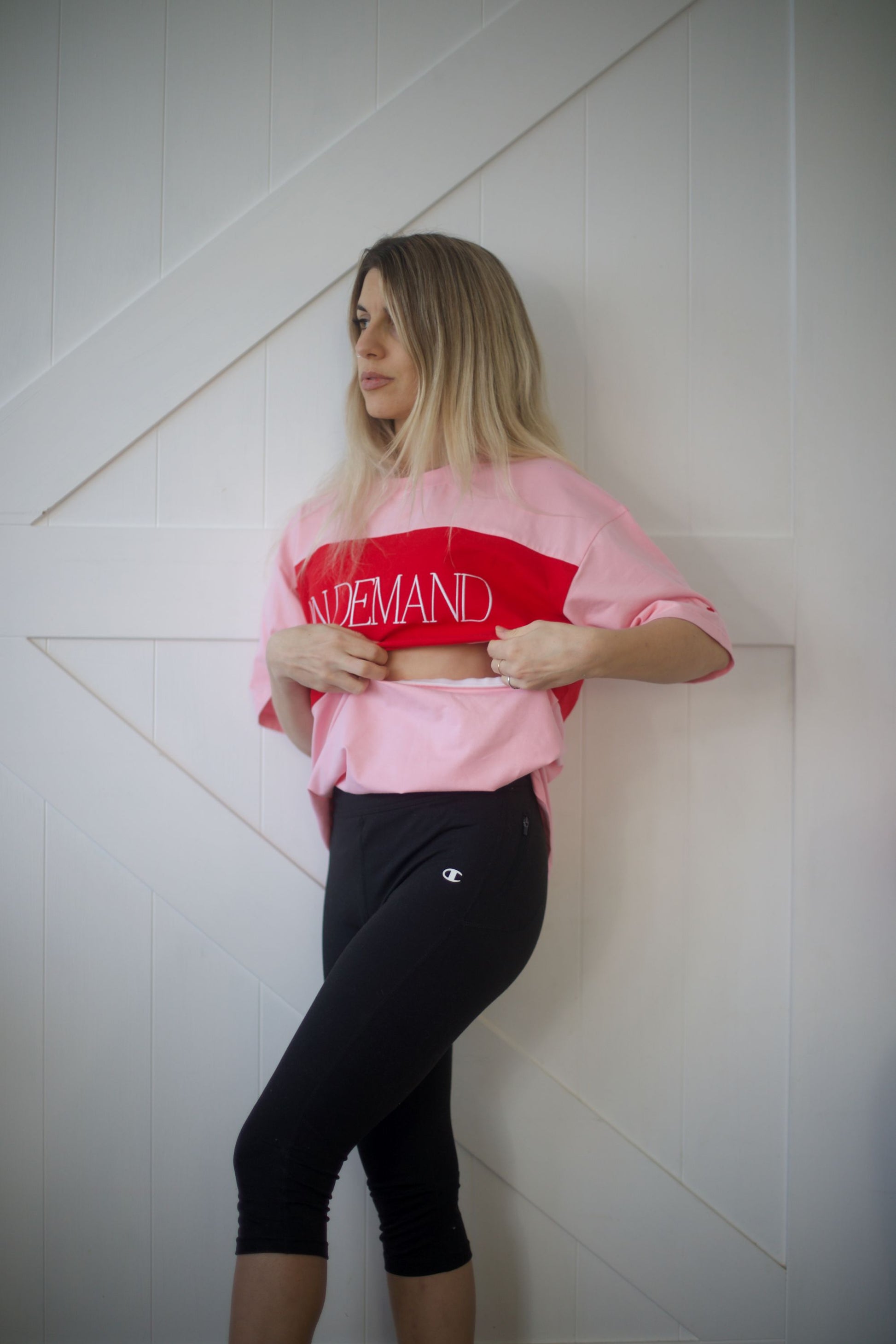 Model demonstrating the discreet side zip breastfeeding access on the pink On Demand t-shirt.