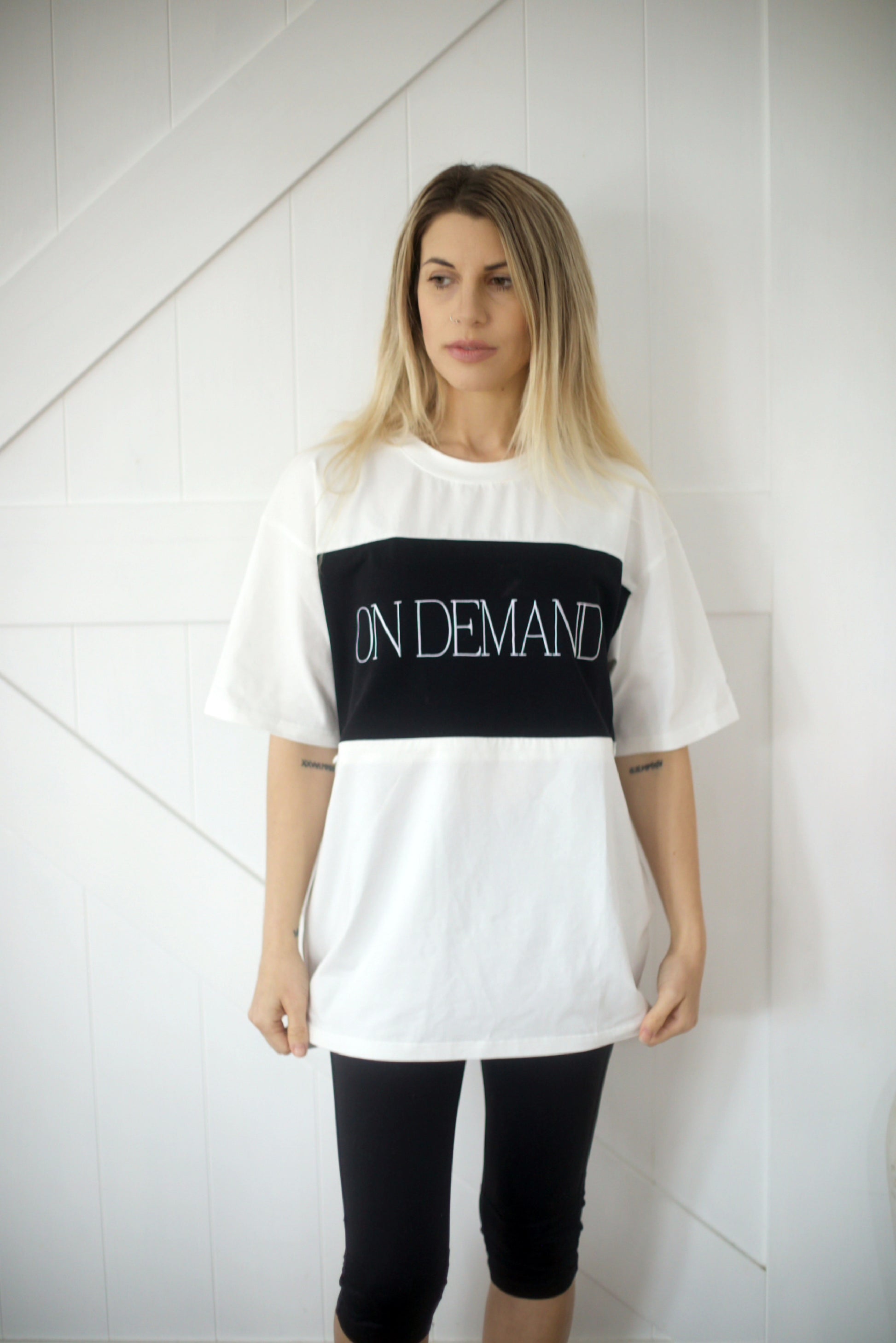 Front view of white breastfeeding t-shirt with black On Demand embroidery, worn by model – discreet zip access for nursing mothers